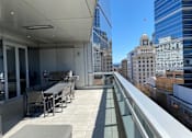Thumbnail 19 of 78 - A balcony with a table and chairs overlooking a cityscape.