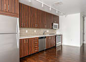 Thumbnail 63 of 78 - A kitchen with wooden cabinets and a white refrigerator.