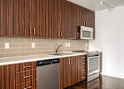 Thumbnail 57 of 78 - A kitchen with brown cabinets and a white counter.