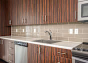 Thumbnail 65 of 78 - A kitchen with wooden cabinets and a white counter top.