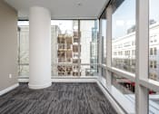 Thumbnail 25 of 78 - A room with a large white column and a view of the city through the windows.
