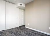 Thumbnail 36 of 78 - A room with a white door and a grey carpet.