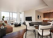 Thumbnail 4 of 36 - A modern living room with a brown sofa, a black coffee table, and a flat screen TV.