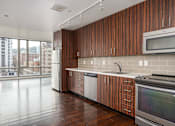 Thumbnail 67 of 78 - A kitchen with wooden cabinets and a stainless steel oven.