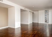 Thumbnail 60 of 78 - A large empty room with wooden floors and white walls.