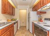 Thumbnail 12 of 34 - a kitchen with wood cabinets and white appliances at Arbors at Windsor Lake, South Carolina   