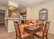 Thumbnail 11 of 34 - a dining area with a table and chairs and a kitchen in the background at Arbors at Windsor Lake, Columbia, 29223  