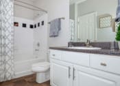 Thumbnail 30 of 31 - a bathroom with a shower and a toilet and a sink at Carrington Place at Wildewood, South Carolina   