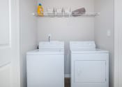 Thumbnail 29 of 31 - a small laundry room with two washes and a dryer at Carrington Place at Wildewood, Columbia South Carolina   