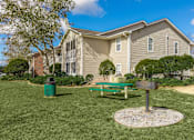 Thumbnail 27 of 34 - a picnic table and grill sit in a grassy area in front of an apartment building at Arbors at Windsor Lake, South Carolina, 29223