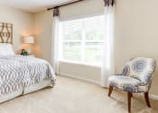 Thumbnail 12 of 17 - a bedroom with a bed and a chair at The Bristol Apartments, Greenville, South Carolina