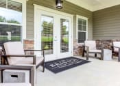Thumbnail 6 of 17 - a patio with chairs and a rug in front of a door at The Bristol Apartments, South Carolina 29601
