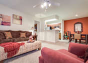 Thumbnail 9 of 34 - a living room with a brown couch and a red chair at Arbors at Windsor Lake, South Carolina, 29223