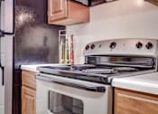 Thumbnail 8 of 34 - a kitchen with a stove top oven next to a refrigerator at Arbors at Windsor Lake, Columbia, SC  