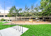 Thumbnail 3 of 25 - A playground with a swing set and a slide.