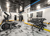 Thumbnail 9 of 25 - A gym with a treadmill, weights, and exercise equipment.