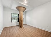 Thumbnail 13 of 25 - A room with a large column in the middle of it.