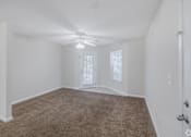 Thumbnail 2 of 23 - A room with a carpeted floor and a ceiling fan.