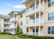 Thumbnail 4 of 6 - a row of apartments with balconies and a yard