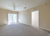 Thumbnail 5 of 16 - A spacious room with a ceiling fan and carpeted floor.