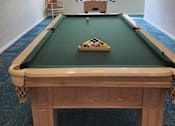 Thumbnail 12 of 21 - A pool table with a green felt cloth and a set of pool balls on it.