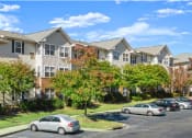 Thumbnail 6 of 6 - an apartment building with cars parked in front of it