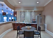 Thumbnail 8 of 17 - A kitchen with a table and chairs in the foreground and a refrigerator in the background at The Bristol Apartments, Greenville, 29601