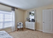 Thumbnail 13 of 17 - A bedroom with a bed, chair, and dresser at The Bristol Apartments, Greenville, South Carolina