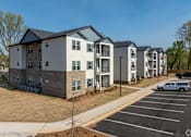 Thumbnail 21 of 23 - A row of townhouses with a white van parked in the driveway at Dunean Creek Apartments, Greenville, SC