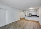 Thumbnail 8 of 23 - a living room with a kitchen in the background
