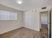 Thumbnail 7 of 23 - a bedroom with hardwood floors and white walls