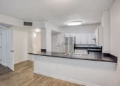 Thumbnail 9 of 23 - a kitchen with a large island and a stainless steel refrigerator