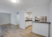 Thumbnail 5 of 23 - an empty living room with a kitchen in the background