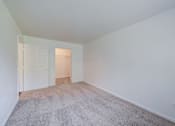 Thumbnail 8 of 10 - a bedroom with a carpeted floor and a door to a closet at Carolina Springs Apartments, Carrboro, NC  