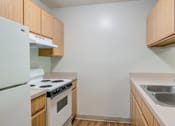 Thumbnail 2 of 10 - a kitchen with white appliances and wooden cabinets at Carolina Springs Apartments, North Carolina, 27510