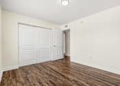 Thumbnail 5 of 19 - A room with a white door and a brown floor.