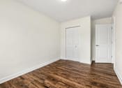 Thumbnail 4 of 19 - A room with wood flooring and two white doors.
