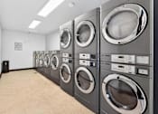 Thumbnail 17 of 19 - A row of washing machines in a laundromat.