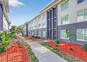 Thumbnail 18 of 19 - A long building with a red mulch strip in front.