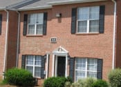 Thumbnail 12 of 13 - a brick house with black shutters and a sidewalk in front of it