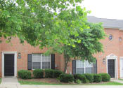 Thumbnail 6 of 13 - a building with trees and bushes in front of it