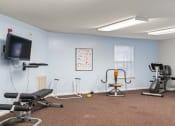 Thumbnail 4 of 6 - a fitness center with exercise equipment and a tv on the wall