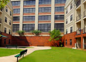 Thumbnail 11 of 18 - a bench in a courtyard in front of an apartment building