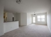 Thumbnail 5 of 18 - an empty living room with a kitchen in the background