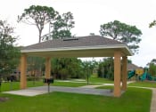 Thumbnail 4 of 7 - a pavilion with a playground and trees in a park
