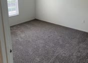 Thumbnail 6 of 15 - an empty room with a carpet floor and a window