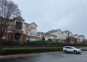 Thumbnail 11 of 15 - a white car parked in front of a row of houses
