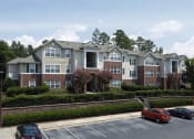 Thumbnail 10 of 15 - an apartment building with cars parked in a parking lot
