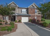 Thumbnail 5 of 31 - a large brick house with a white garage door in front of it at Carrington Place at Wildewood, Columbia, SC  