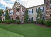 Thumbnail 2 of 31 - front view of a house with green lawn and shrubs at Carrington Place at Wildewood, Columbia, 29223  